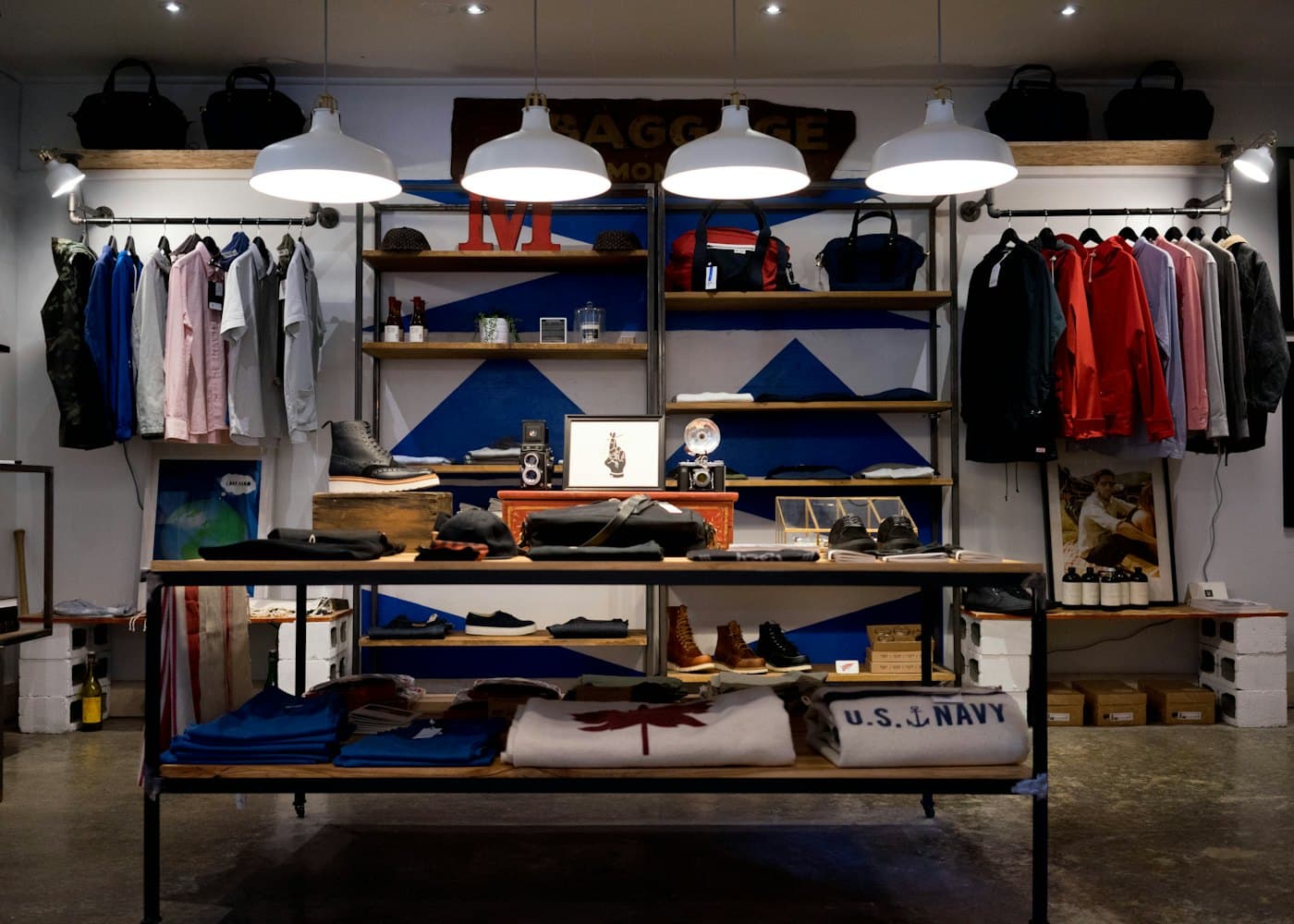 A stocked retail shop interior with clothing rails and shelves